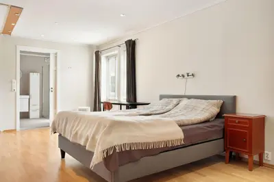 a bedroom with a bed and a dresser and a window at 4-Bedroom Apartment with Balcony in Odda