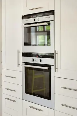 a kitchen with white cabinets and an oven at 4-Bedroom Apartment with Balcony in Odda