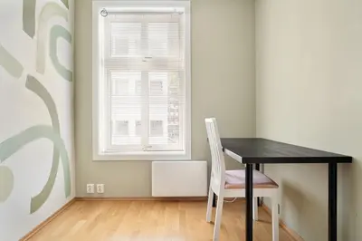 a black table and a chair in a room with a window at 4-Bedroom Apartment with Balcony in Odda