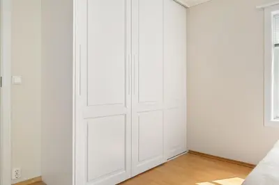 a white closet with white walls and wood floors at 4-Bedroom Apartment with Balcony in Odda