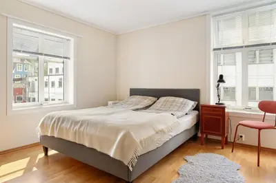 a bedroom with a bed and two windows at 4-Bedroom Apartment with Balcony in Odda