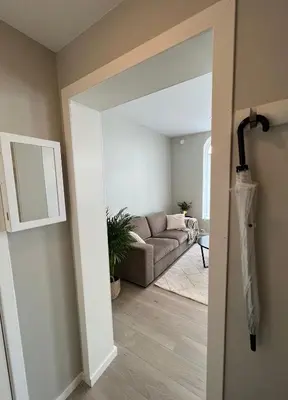 an open door into a living room with a couch at Attractive and central apartment in Ålesund