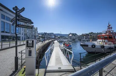 a marina with boats in the water and a street sign at Attractive and central apartment in Ålesund