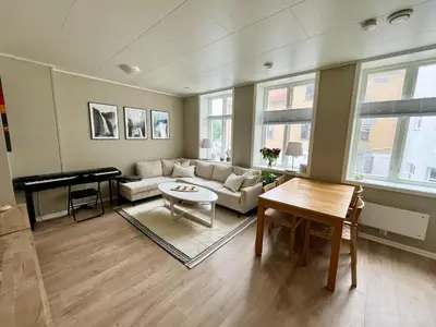 a living room with a couch and a table and a piano at Central apartment in Bergen City Center in Bergen