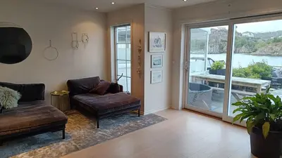 a living room with a couch and a glass door at Koselig hus med egen brygge in Askøy