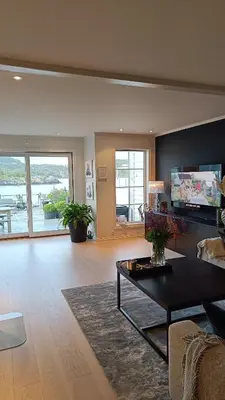 a living room with a couch and a table at Koselig hus med egen brygge in Askøy