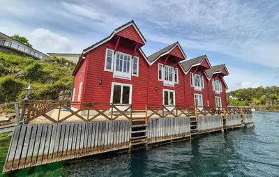 a red house on a dock in the water at Cozy Home In Lepsøy With House Sea View in Lepsøy