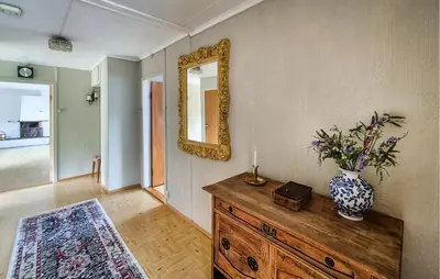 a room with a dresser with a mirror and a vase on it at Awesome Home In Fitjar With Wifi in Fitjar