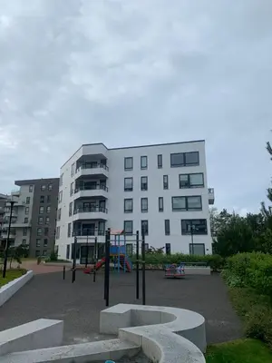 a playground in front of a white building with a playground at Lys og moderne 3-roms på Sandsli in Bergen