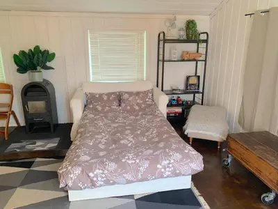a bedroom with a bed and a stove in it at Cabin at Hestsjøen Badeplass in Trondheim