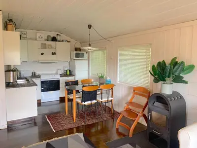 a kitchen with a table and chairs in a room at Cabin at Hestsjøen Badeplass in Trondheim