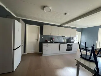a kitchen with white appliances and blue walls at Hus nær butikk, sentrum & rekreasjon in Hol