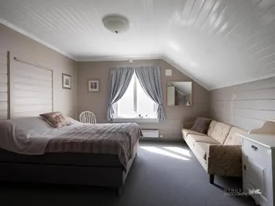 a bedroom with a bed and a couch and a window at Hus nær butikk, sentrum & rekreasjon in Hol