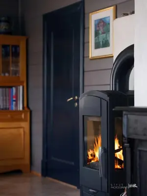 a fireplace with a fire in it next to a door at Hus nær butikk, sentrum & rekreasjon in Hol