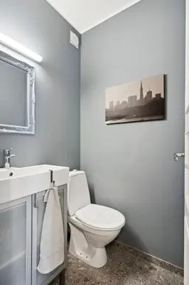 a bathroom with a white toilet and a sink at A Gem in the Heart of Ålesund in Ålesund