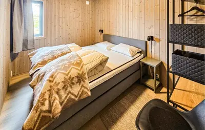 a large bed in a room with a bedskirtspectspectspectspects at 4 Bedroom Nice Home In Vinje in Trovatn