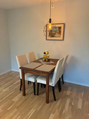 a dining room table with chairs and a bowl of fruit on it at FINN-bruker in Lii