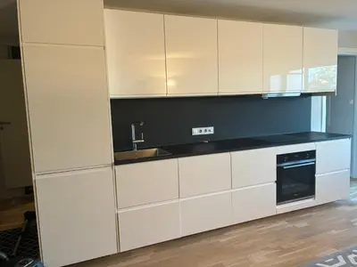 a kitchen with white cabinets and a sink at FINN-bruker in Lii