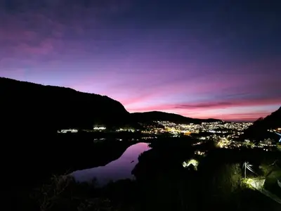 a night view of a city and a body of water at Cozy flat with lake view and 15 min from Bergen in Bergen