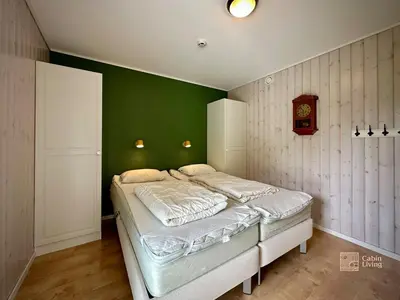 a bedroom with a bed with a green wall at Family friendly apartment in Hafjell ski in-out, fireplace, sauna and wifi in Hafjell