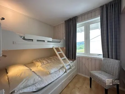 a bedroom with two bunk beds and a chair at Family friendly apartment in Hafjell ski in-out, fireplace, sauna and wifi in Hafjell