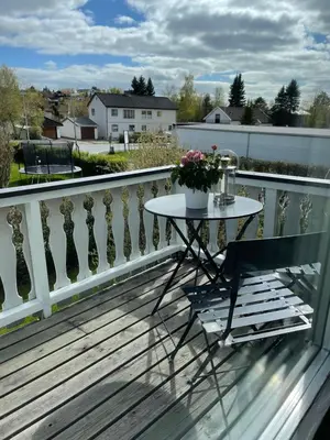 a table and a chair on a balcony at Small apartment with 4 bedrooms close to city in Trondheim