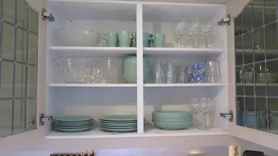 a kitchen cabinet filled with dishes and glasses at Stavetunet in Stadlandet