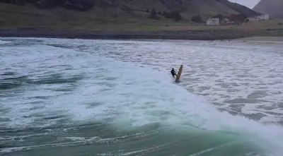 a person on a surfboard in a body of water at Stavetunet in Stadlandet