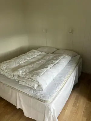 an unmade bed in a bedroom with white sheets at Apartment Øvre Tråstølen - Voss in Vossevangen