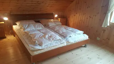 a bed with white sheets and pillows in a room at Gorgeous views and sunsets in Halsnøy, Kvinnherad in Ådnavik