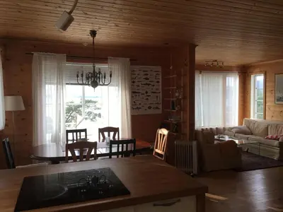 a kitchen and living room with a table and chairs at Gorgeous views and sunsets in Halsnøy, Kvinnherad in Ådnavik