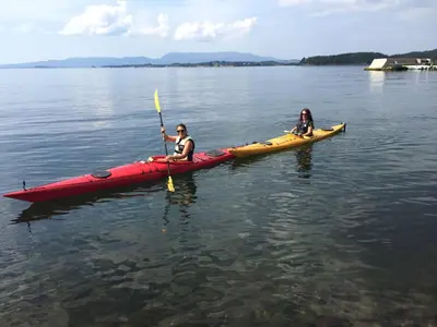 two people in a kayak on a body of water at Gorgeous views and sunsets in Halsnøy, Kvinnherad in Ådnavik