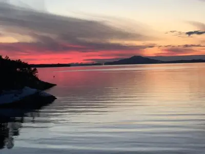 a sunset over a large body of water at Gorgeous views and sunsets in Halsnøy, Kvinnherad in Ådnavik