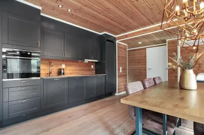 a kitchen with black cabinets and a wooden ceiling at Large nice apartment in Myrkdalen in Vossevangen