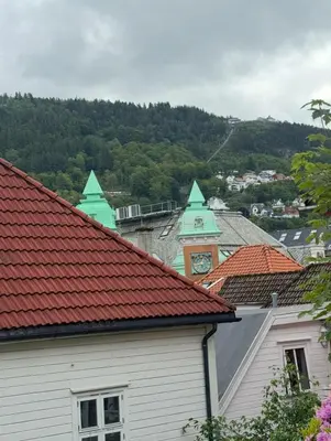 a building with red roofs and a clock tower at Modern central apartment in a quiet area in Bergen