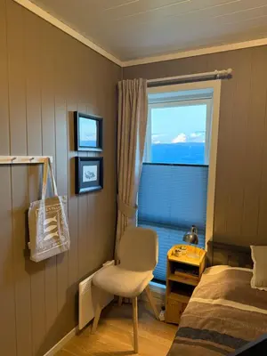 a bedroom with a bed and a chair and a window at Ski in-Ski out with Mountain View at Voss in Vossevangen