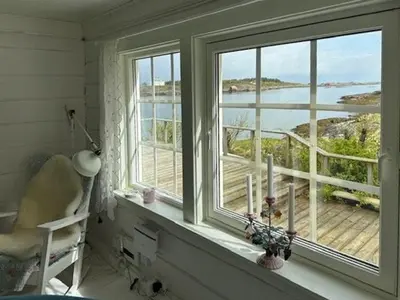 a room with a window with a view of the ocean at Historic Cabin By The Atlantic Ocean Road in Vevang