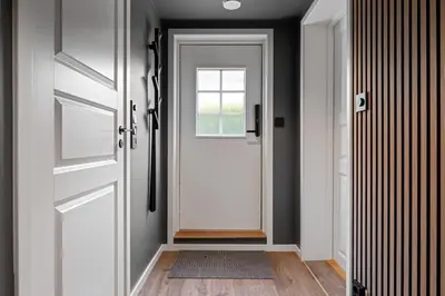 a hallway with a white door and a window at King bed - Free parking - Renovated June 2025 in Bergen