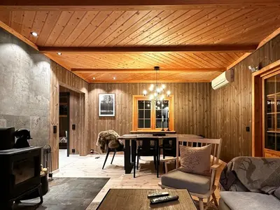 a living room with a wooden ceiling and a table at Nature-Close Cabin By Trysil Mountain in Trysil