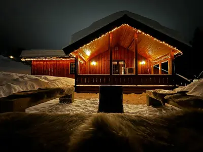 a log cabin with lights on it in the snow at Nature-Close Cabin By Trysil Mountain in Trysil