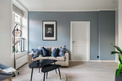 a living room with blue walls and a couch at Bergen Beds Apartments - Unbeatable location! in Bergen