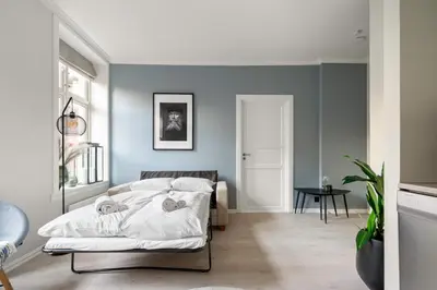 a bedroom with blue walls and a bed at Bergen Beds Apartments - Unbeatable location! in Bergen