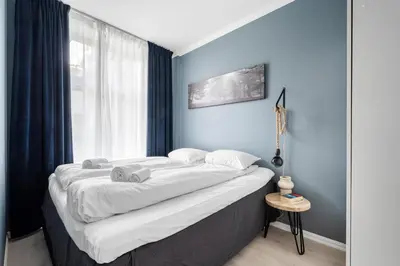 a bedroom with a large bed with blue walls at Bergen Beds Apartments - Unbeatable location! in Bergen