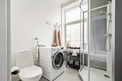 a bathroom with a washing machine and a toilet at Bergen Beds Apartments - Unbeatable location! in Bergen