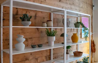 a white shelving unit with pots and plants on it at Authentic Bergen Apartment in Bergen