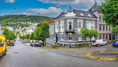a city street with a large white building on the corner at Authentic Bergen Apartment in Bergen