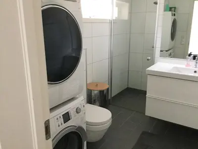 a bathroom with a washer and a toilet and a sink at Lade - Aqua Nor 2025 - inntil 7 personer in Lii