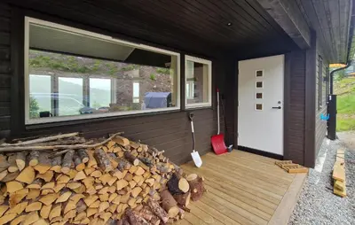 a cabin with a pile of fire wood next to a door at Nice Home In Hafslo With Wifi in Hafslo