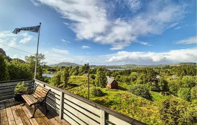 a bench sitting on a wooden deck with a flag at Amazing Home In Frekhaug in Frekhaug
