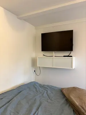 a bedroom with a flat screen tv on a wall at Entire home with pool and garden in Ålesund